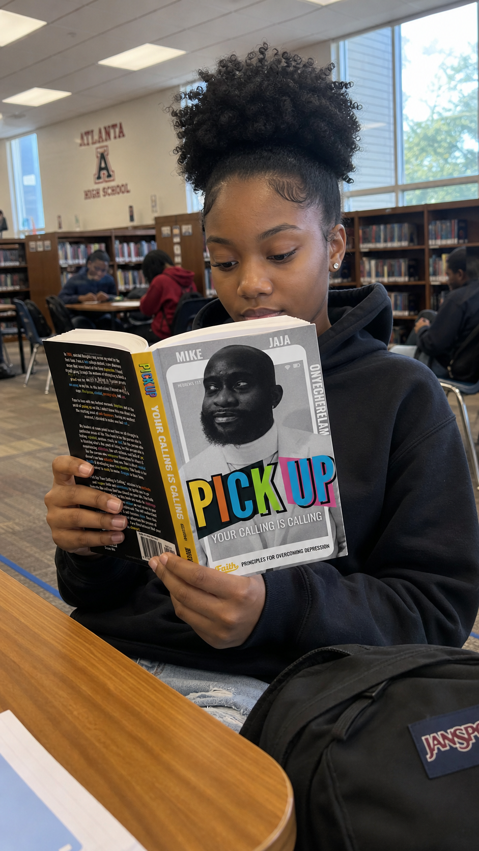 A reader studying Pick Up: Your Calling Is Calling in a library.